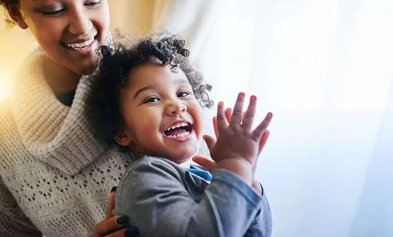 Smiling child with parent representing support services for parents and families through First 5 Sonoma County
